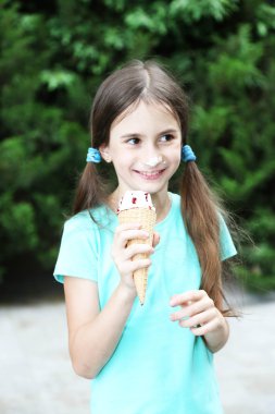 park arka plan lezzetli dondurma yiyen küçük kız paten