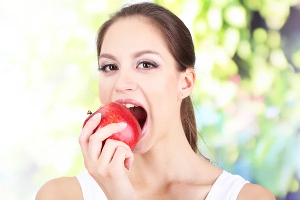 Young woman with apple on bright background Stock Image