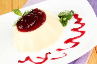 Panna cotta ahşap zemin üzerinde frambuaz sos ile