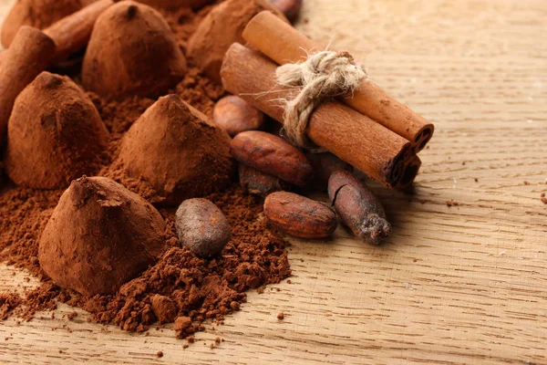 Samenstelling van chocolade truffels, cacao en specerijen op houten achtergrond — Stockfoto