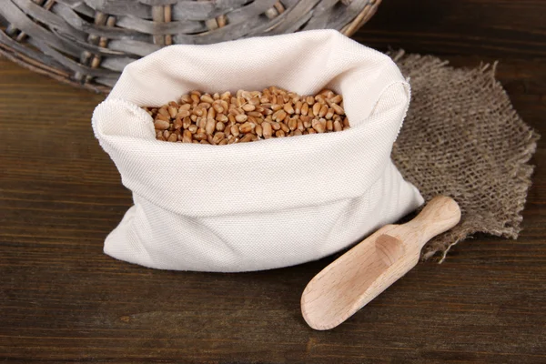Grains in sack on wooden background — Stock Photo, Image