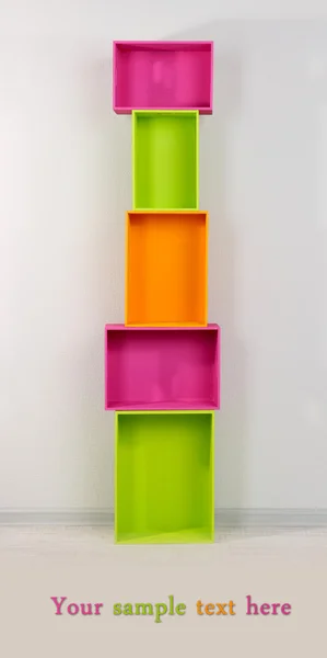 Beautiful colorful crates as shelves standing in room — Stock Photo, Image