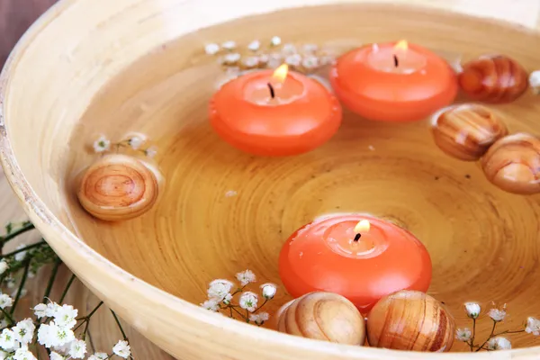 Belas velas na água na mesa de madeira close-up — Fotografia de Stock