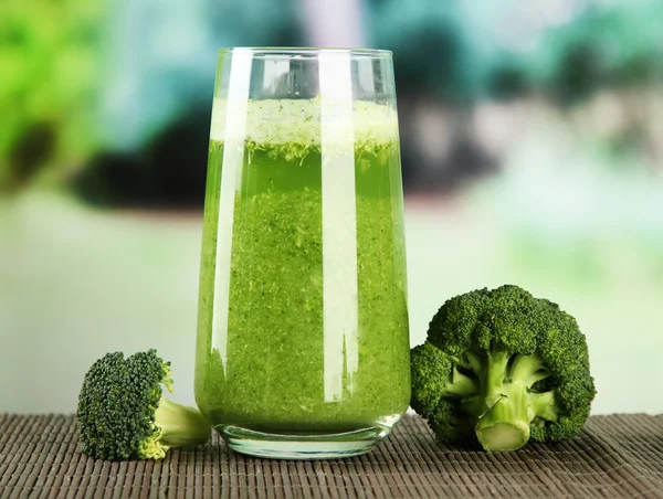 Glas broccoli sap, op bamboe mat, op groene ondergrond — Stockfoto