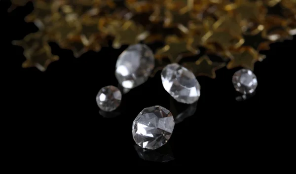 Belos cristais brilhantes (diamantes) e estrelas douradas, sobre fundo preto — Fotografia de Stock