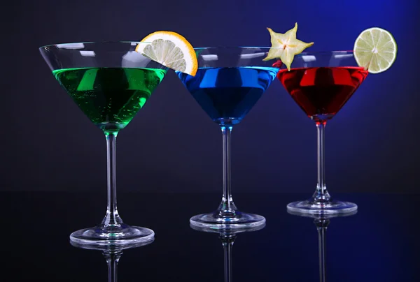 Coquetéis alcoólicos em copos de martini no fundo azul escuro — Fotografia de Stock