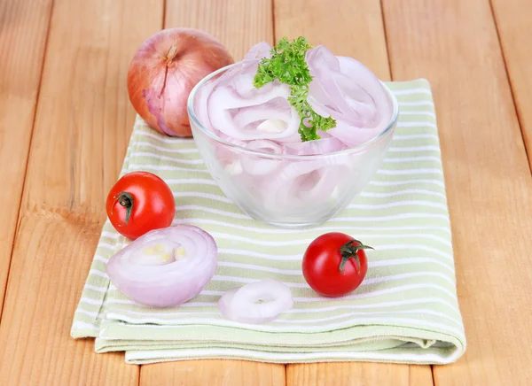 Onion cut with rings in bowl on wooden table close-up — Stock Photo, Image