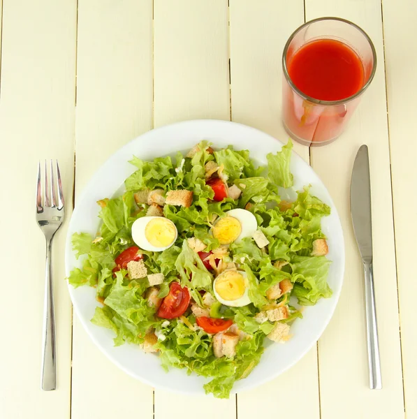 Salada Caesar na placa branca, na cor de fundo de madeira — Fotografia de Stock