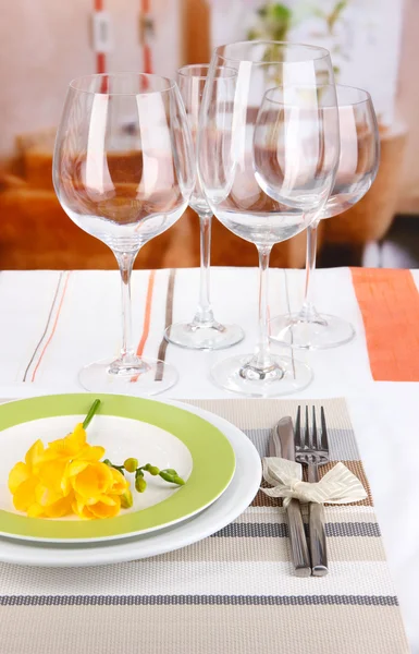 Table setting with glasses for different drinks on table on room background — Stock Photo, Image