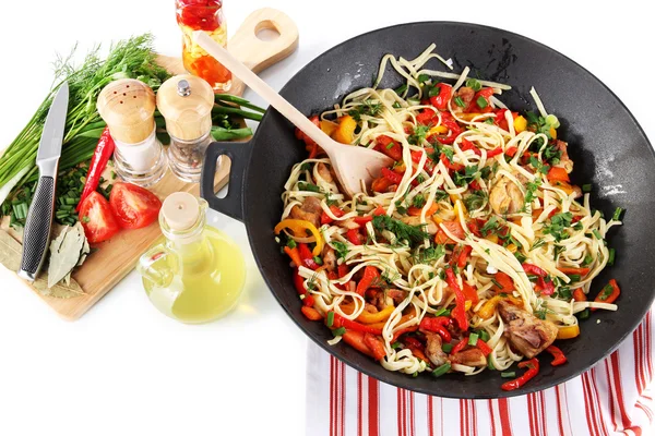 Noodles with vegetables in wok on bright background — Stock Photo, Image