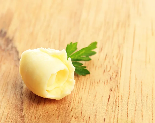 Butter curl on wooden table — Stock Photo, Image