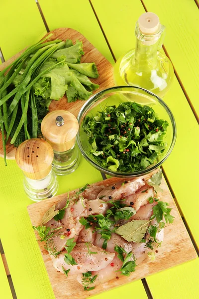 Chicken meat in glass plate,herbs and spices on wooden table — Stock Photo, Image