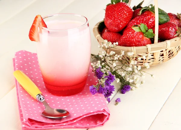 Вкусный клубничный йогурт в стекле на деревянном столе крупным планом — стоковое фото