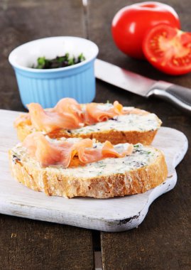 ahşap masa üzerinde kesme tahtası üzerinde balık sandviç