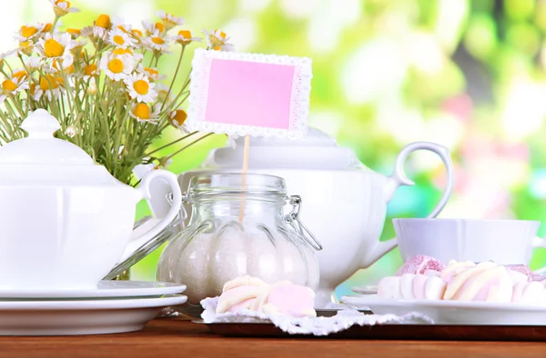 Table setting with chamomiles on wooden table on nature background — Stock Photo, Image