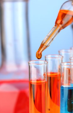 Laboratuvar pipet renkli sıvı cam test tüpleri üzerinde damla ile yakın çekim