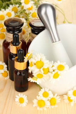 esans ve harç ahşap masa üzerinde papatya çiçeği.