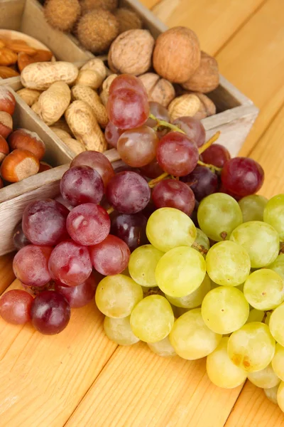 Grape with nuts on wooden table — Stock Photo, Image