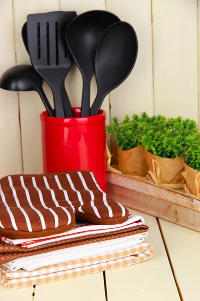 Ajustes de cocina: utensilios, agarraderas, toallas y más en la mesa de madera —  Fotos de Stock