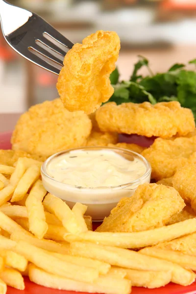 Gebakken kipnuggets met patat en saus op tafel in café — Stockfoto