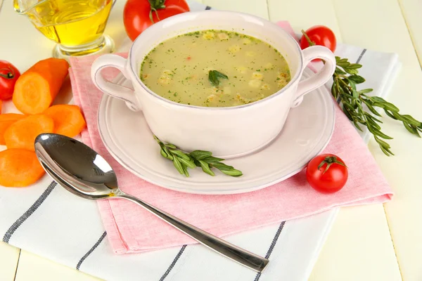 Nourishing soup in pink pan on wooden table close-up — Stock Photo, Image