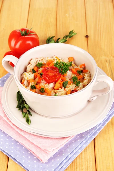 Delicious rice with vegetables and herbs in pot on wooden table close-up — Stock Photo, Image