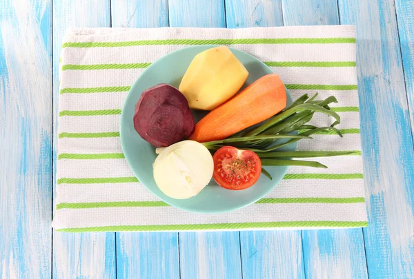 Légumes pelés dans une assiette sur une serviette — Photo