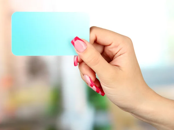 Female hand holding card, on bright background — Stock Photo, Image