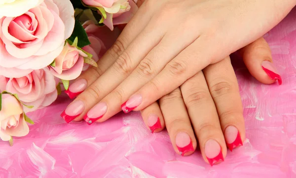 Fechar-se de mãos de mulher jovem com a manicura de elegância, no contexto a cores — Fotografia de Stock