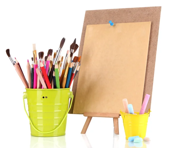 Small easel with sheet of paper with art supplies isolated on white — Stock Photo, Image