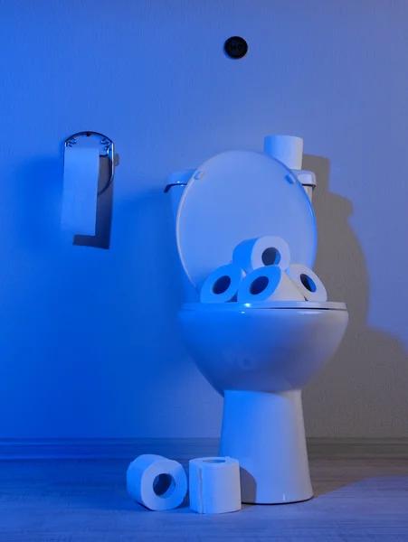 Toalete e papel higiênico em um banheiro com luz azul — Fotografia de Stock
