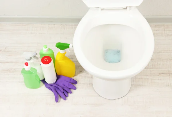 Vit WC-skål och rengöringsmateriel i ett badrum — Stockfoto