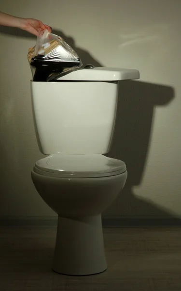 Kézi elrejti a fegyvert és pénzt egy fürdőszoba WC tartály — Stock Fotó