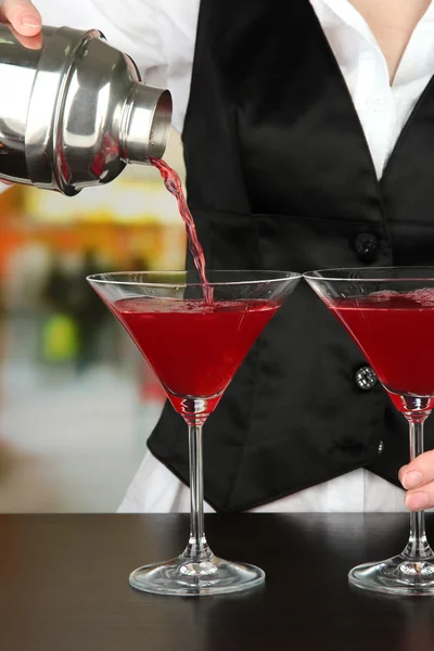 Bartendrar hand med shaker hälla cocktail i glas, på ljus bakgrund — Stockfoto