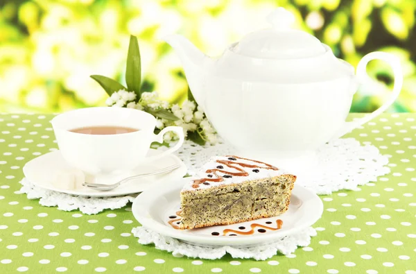 Délicieux gâteau aux graines de pavot avec tasse de thé sur la table sur fond lumineux — Photo
