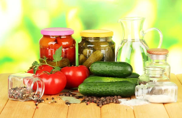 Lezzetli yeşil salatalık ve parlak zemin üzerine ahşap masa üzerinde sepet içinde kırmızı domates — Stok fotoğraf