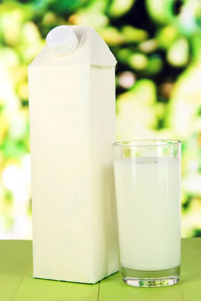 Milk pack on table on bright background — Stock Photo, Image