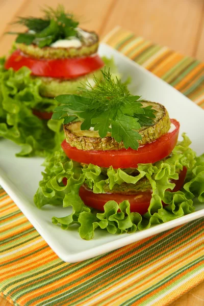 Sabroso tueste de médula y rodajas de tomate con hojas de ensalada, sobre fondo de madera — Foto de Stock