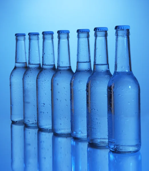 Water bottles on blue background — Stock Photo, Image