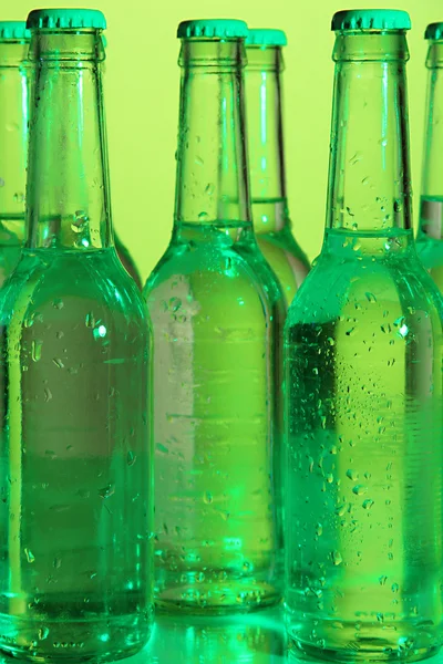 Бутылки с водой на зеленом фоне — стоковое фото