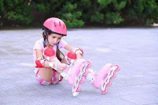 Petite fille en patins à roulettes au parc — Photo