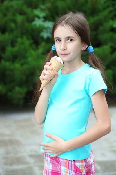 Little girl skates eating tasty ice-cream at park background — Stock Photo, Image