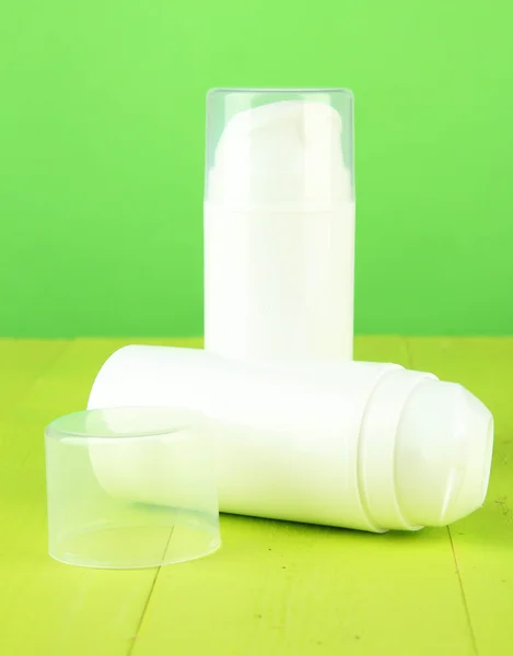 Bottiglia con crema, su sfondo colore — Foto Stock