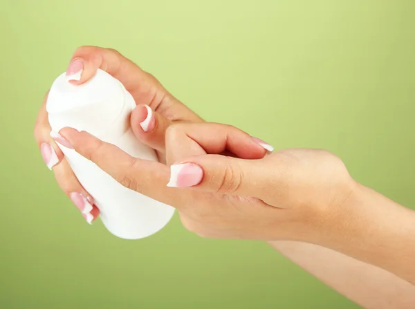 Woman applying cream on hands on color background — Stock Photo, Image