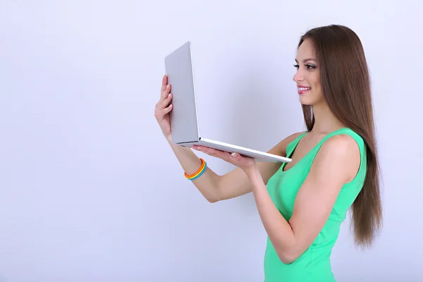 Hermosa mujer joven con ordenador portátil en la habitación —  Fotos de Stock