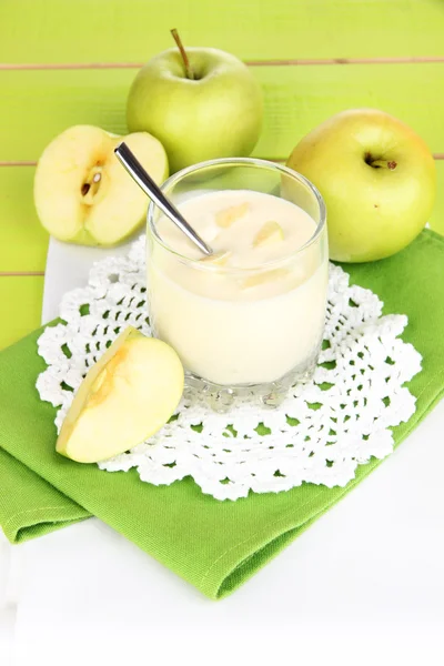 Delizioso yogurt in vetro con mela sulla tovaglia blu — Foto Stock