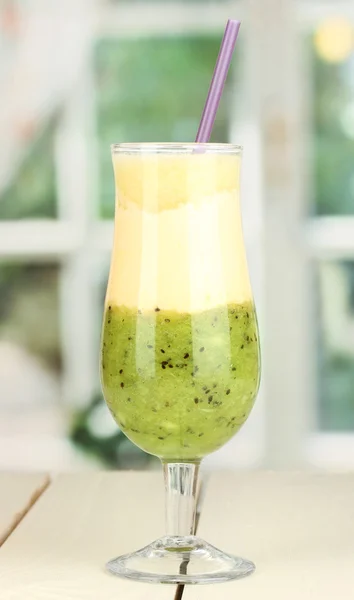 Delicioso batido de frutas sobre mesa de madera sobre fondo de ventana — Foto de Stock