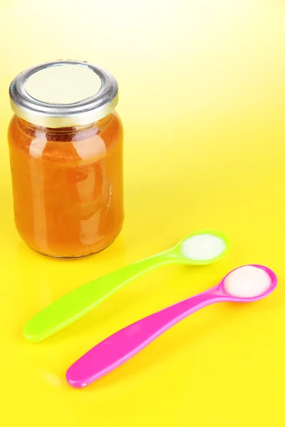 Cucharas de color para alimentos para bebés con nutrición para bebés sobre fondo amarillo —  Fotos de Stock