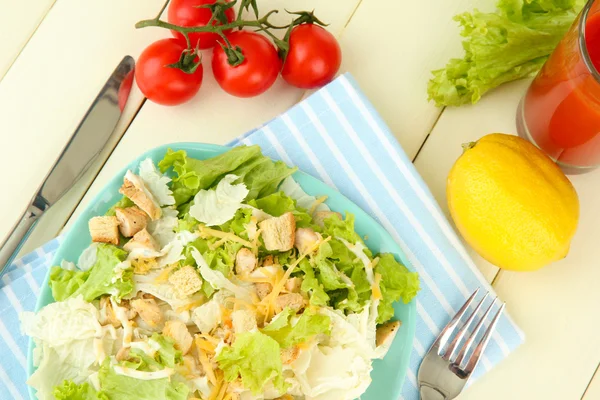 Caesar-Salat auf blauem Teller, auf farbigem Holzhintergrund — Stockfoto