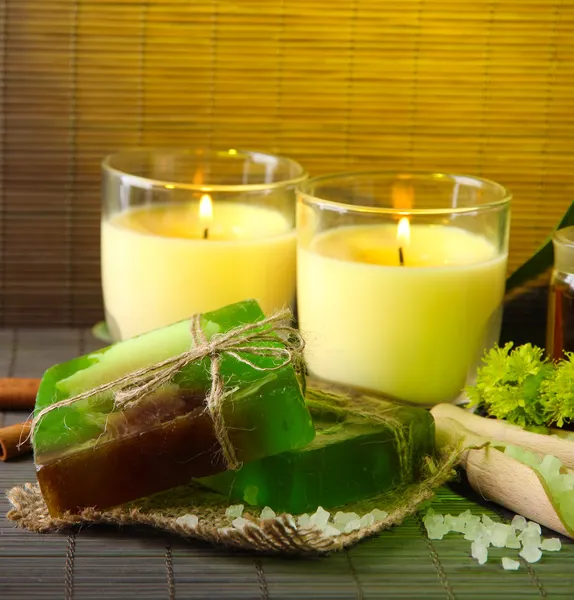 Savon et bougies faits à la main sur fond de tapis de bambou — Photo